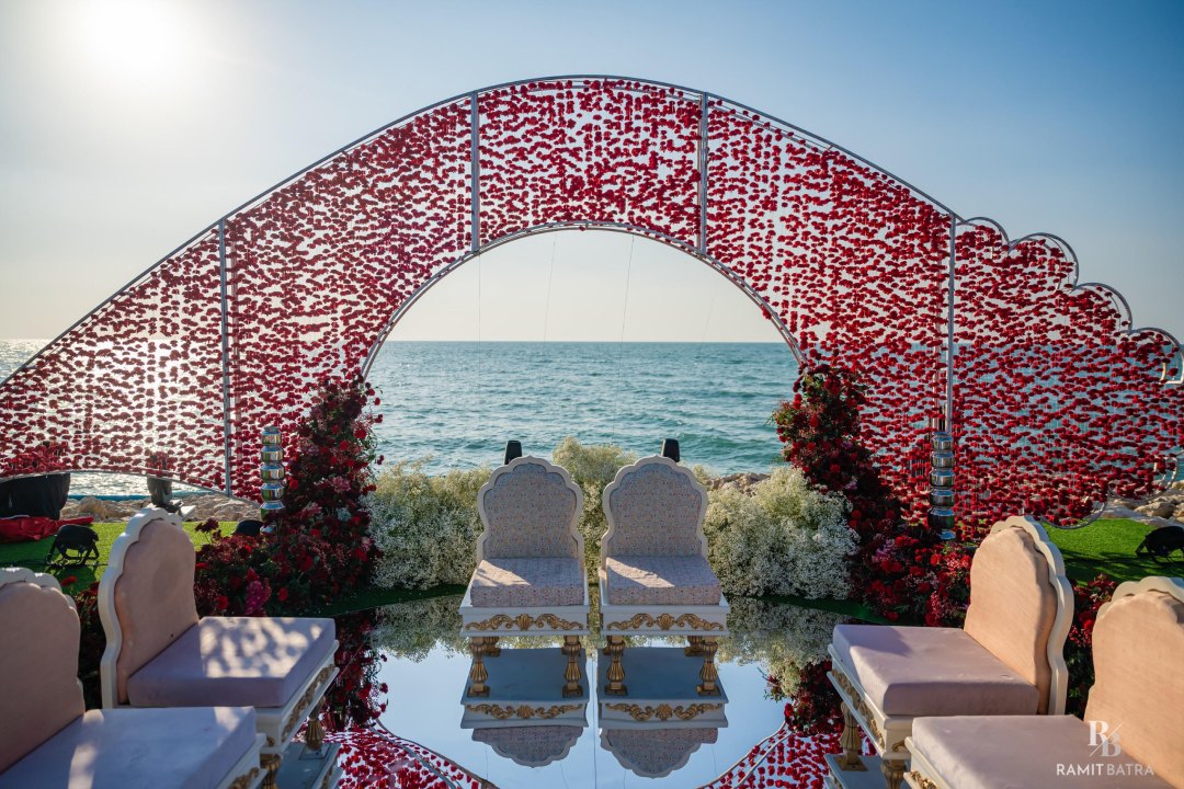 Seaside wedding mandap with a floral arch and ocean view